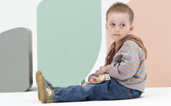 little boy sitting on the floor promoting his new boots