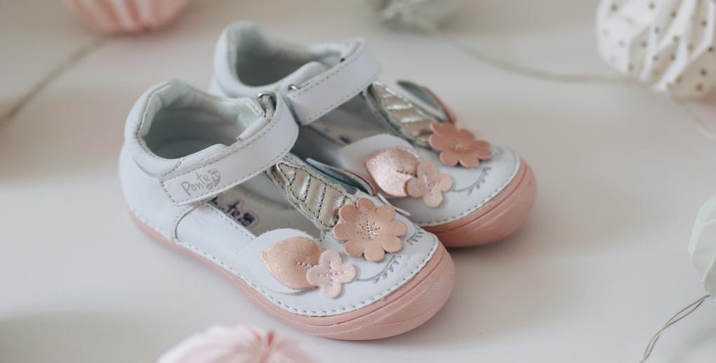 beautiful pair of white leather dress shoes with light pink flower decoration.
